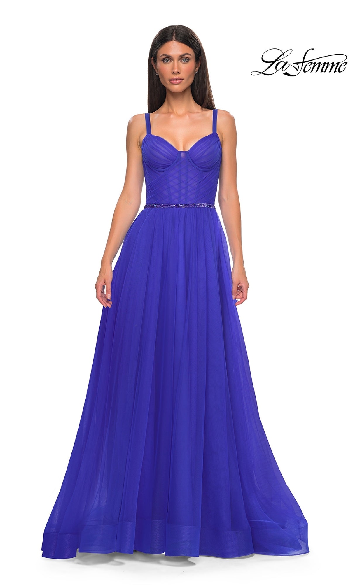 Woman wearing La Femme 32956, a floor-length royal blue A-line prom ball gown with thin straps, fitted corset bodice, and beaded waist; La Femme logo in the top right corner.